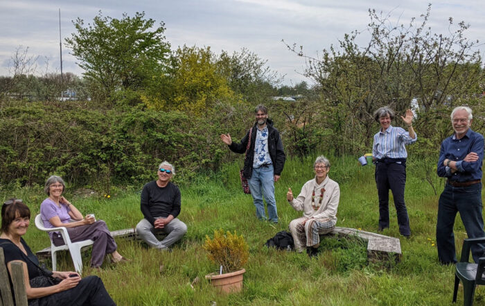 Angel Yard Cohousing Group sat outside in a grassy area