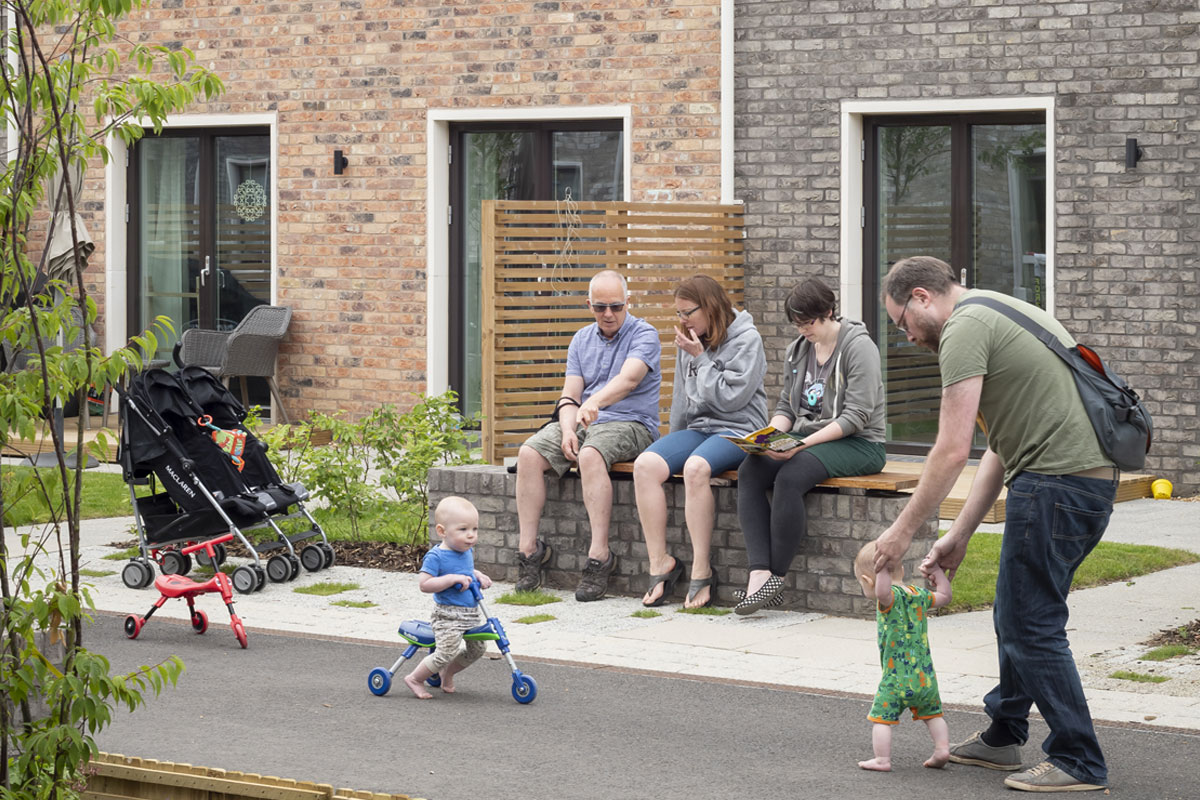 Children and their family play outside homes at Marmalade Lane
